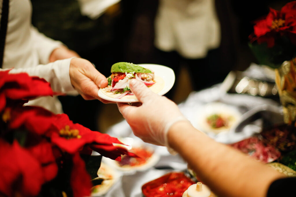 tacos being catered at holiday party with red poinsinettas