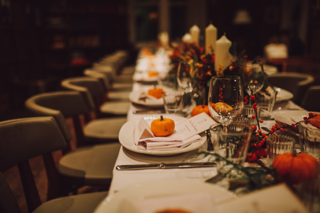 A Thanksgiving dinner spread with place cards and cutlery on the table.