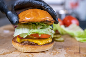 a burger with lettuce, tomato, cheese, and the patty