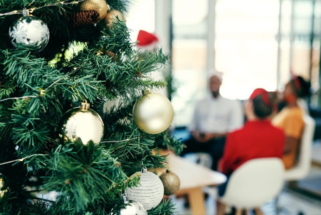 A close up of a christmas tree with individuals gathered around