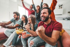 A group of people smiling and cheering on the team