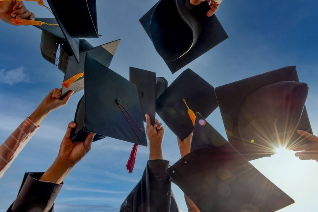 A group of people tossing their graduation caps in the air
